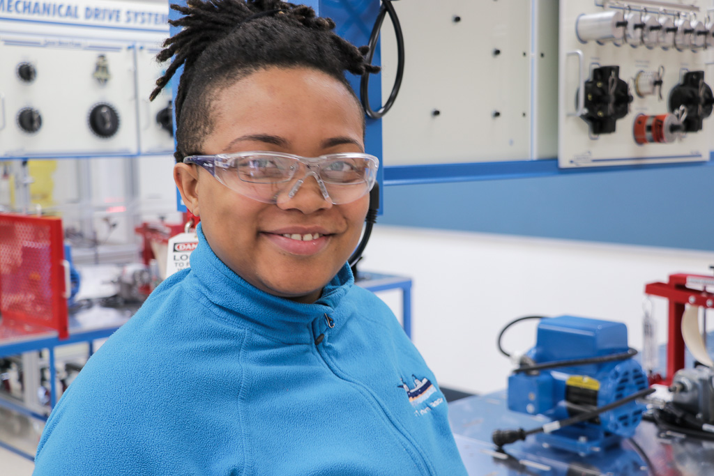 An RTC student in the Mechatronics shop, smiling