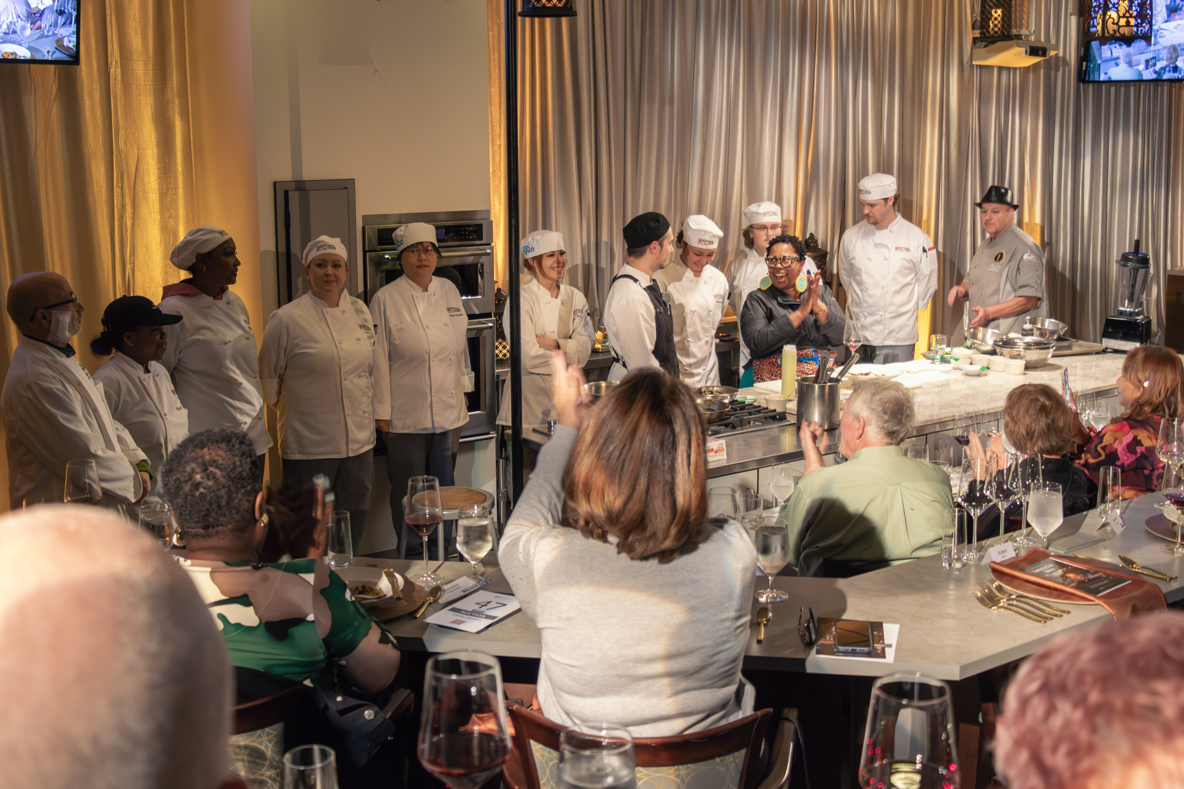 Celebrity Chef Kristi Brown standing in a kitchen smiling and clapping