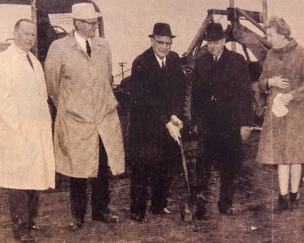 Sepia photo of the ground breaking of RTC, several individuals gathered around