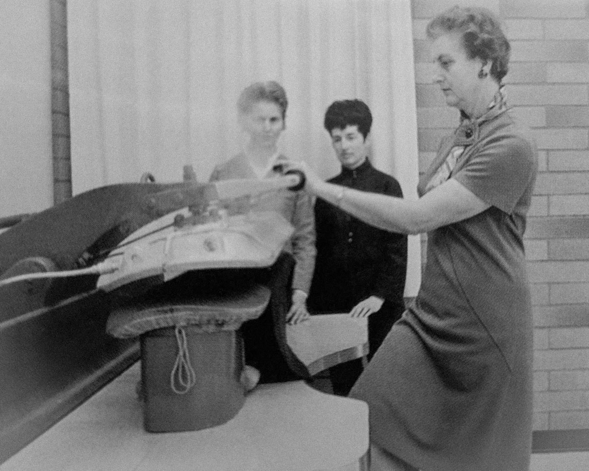 black and white photo of students operating a machine