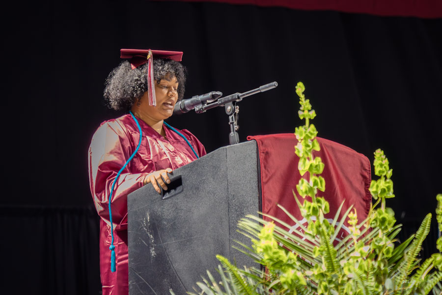 Stacey speaking at the podium during commencement