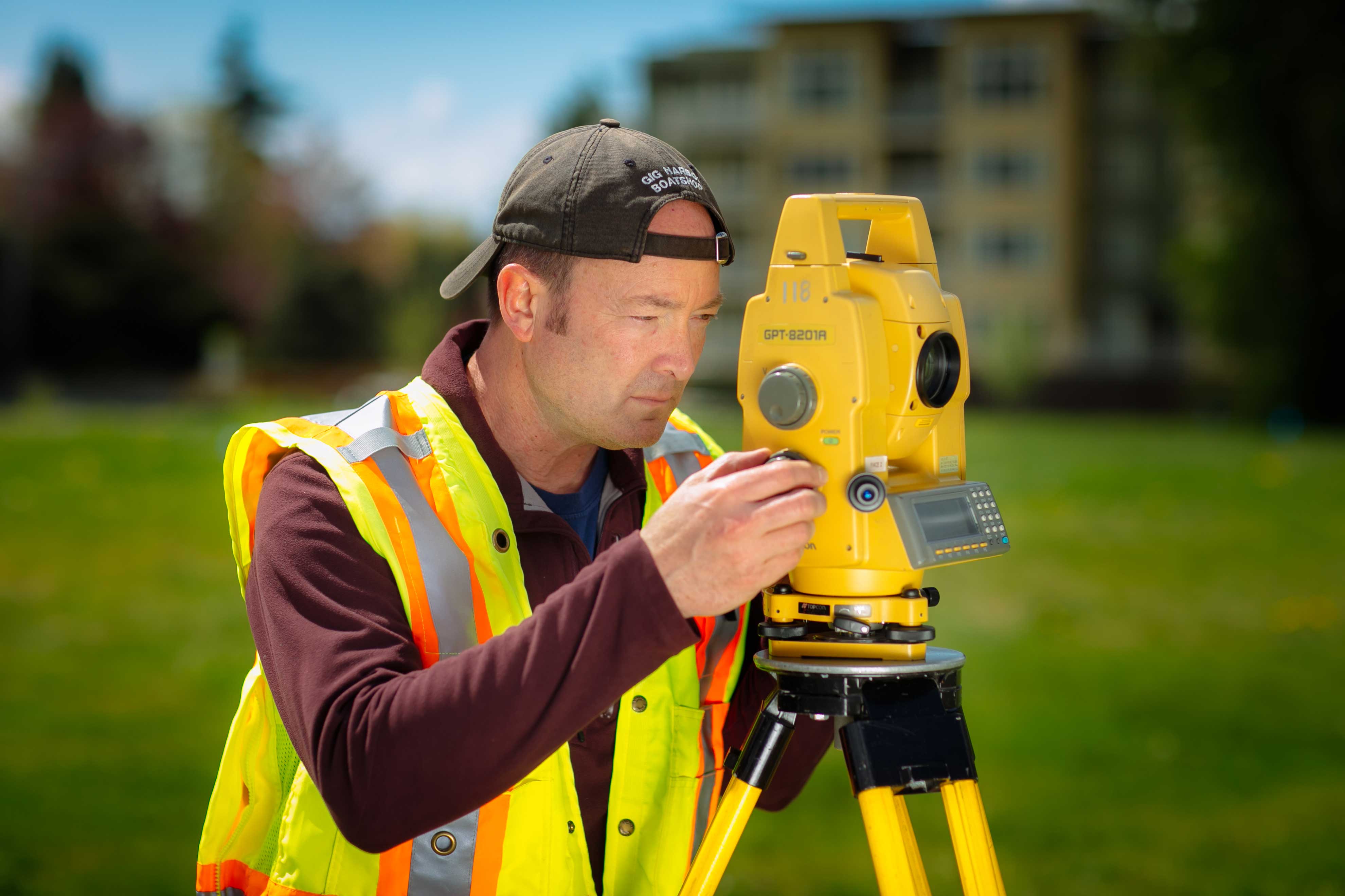 A man using field surveying equipment.