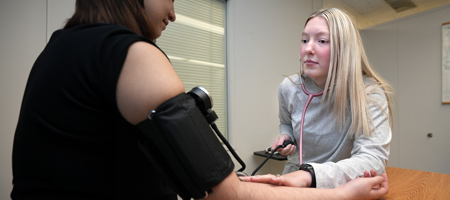 A medical assistant checking blood pressure.